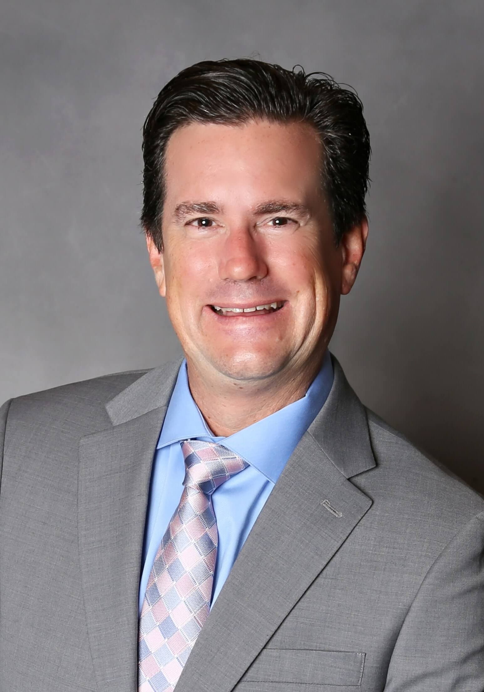 Janowitz Cropped headshot grey suit with background 2023 Janowitz Cropped headshot grey suit with background 2023